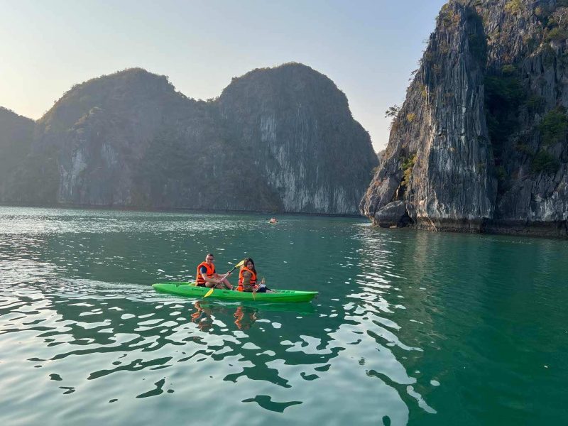 Tourists kayaking through limestone karsts and hidden lagoons in Lan Ha Bay during the 2 days 1 night cruise tour