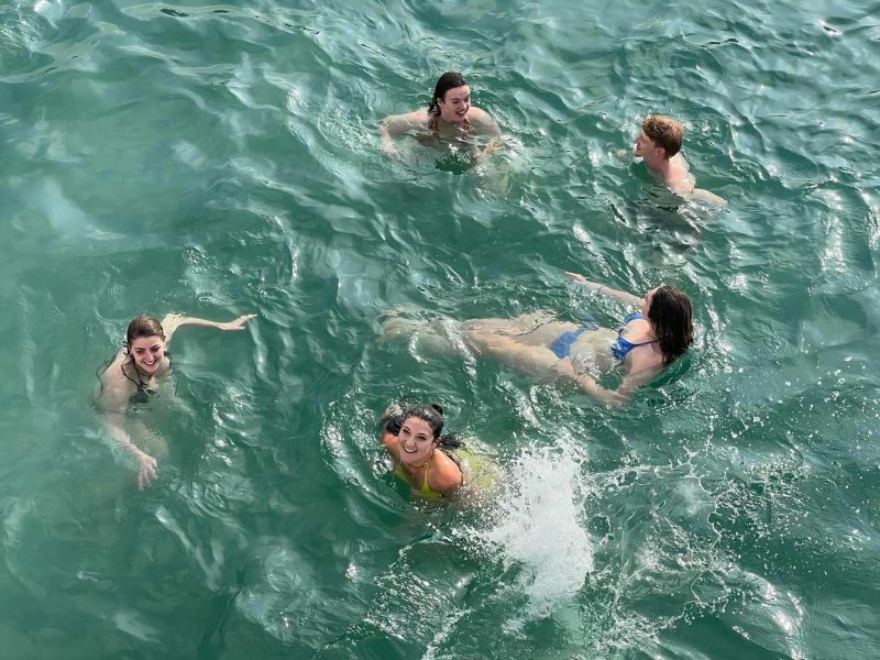 Tourists swimming in the emerald waters of Lan Ha Bay during the half-day luxury tour