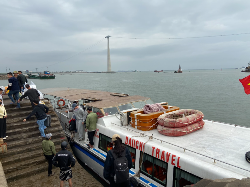 Tourists struggling with heavy luggage during a speedboat transfer, a common hassle avoided on the direct route from Tam Coc